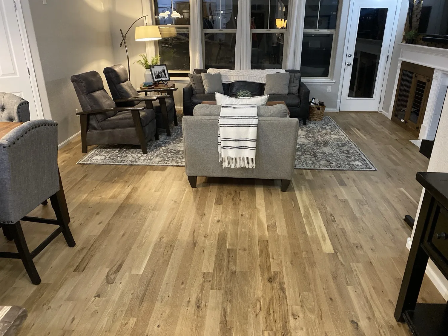 Finished oak floor running through a furnished living room in full daylight