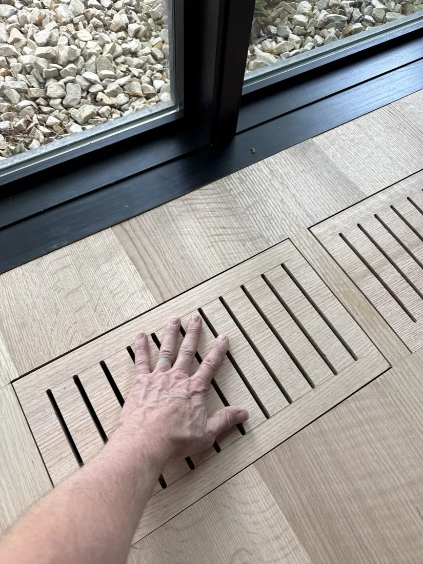 Custom flush-mount wood floor vent cut into a white oak floor
