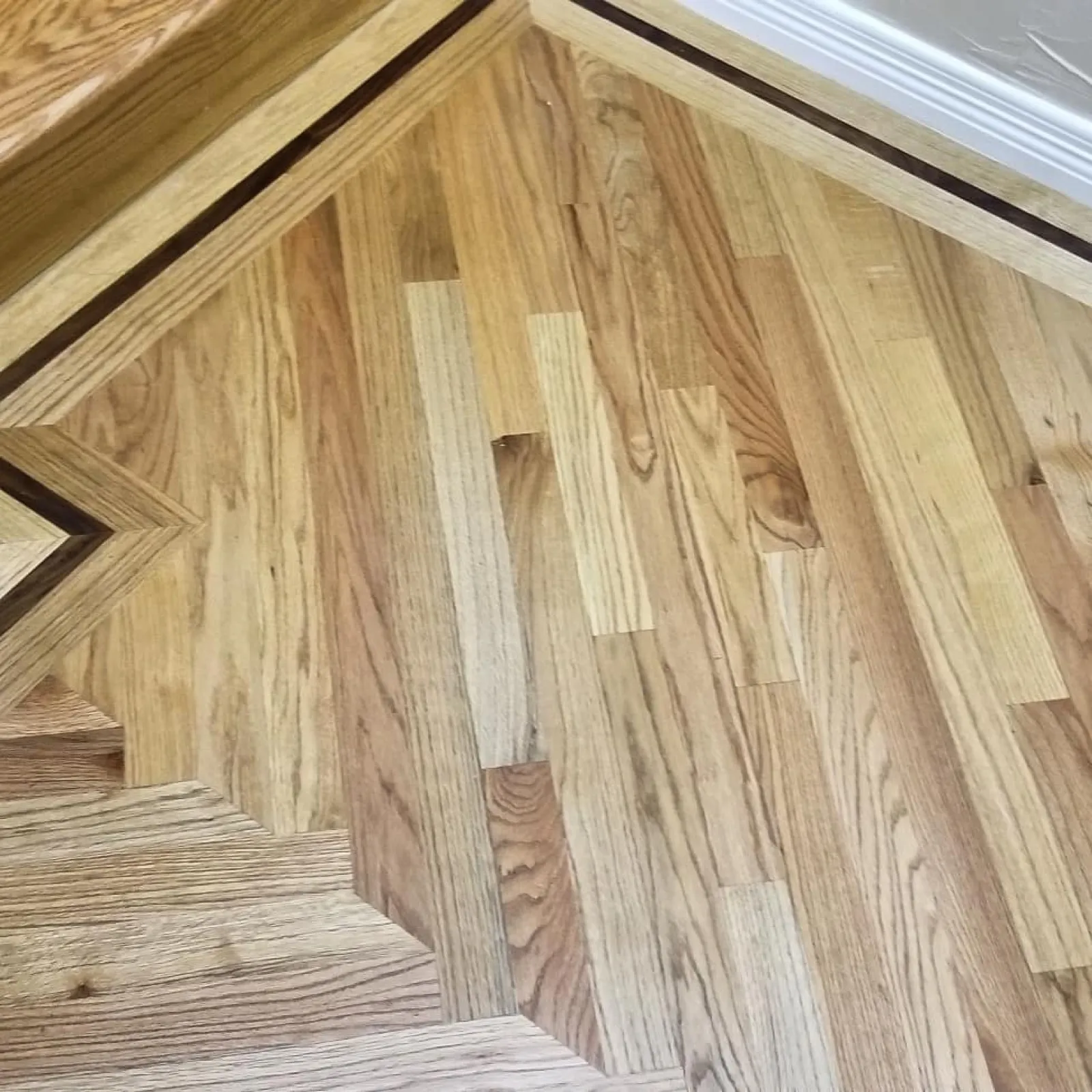 Oak floor sanded back to bare wood with new boards laced into the old field