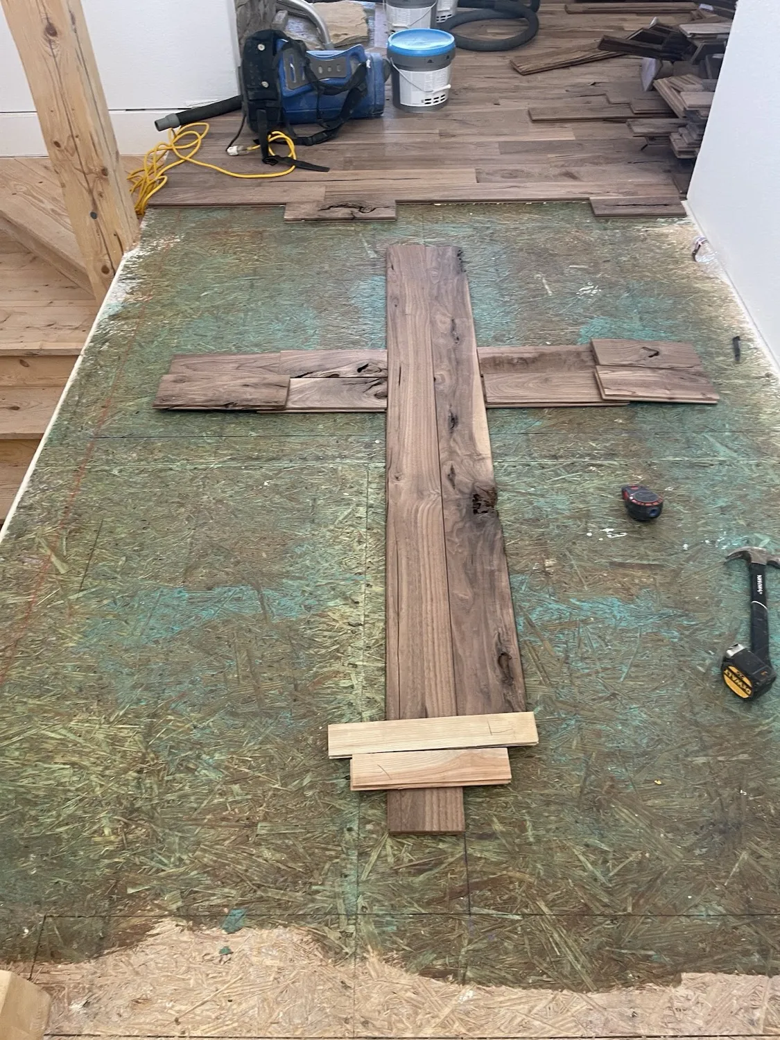 Replacement hardwood boards laid out on an exposed subfloor ready to be laced in